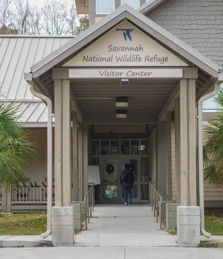 Entrance to the Savannah National Wildlife Refuge Visitor Center with a person walking toward the glass doors.
